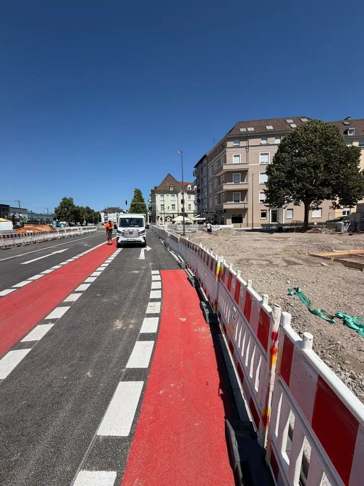 Innerstädtische Baustelle mit Absperrgittern und markiertem Radweg